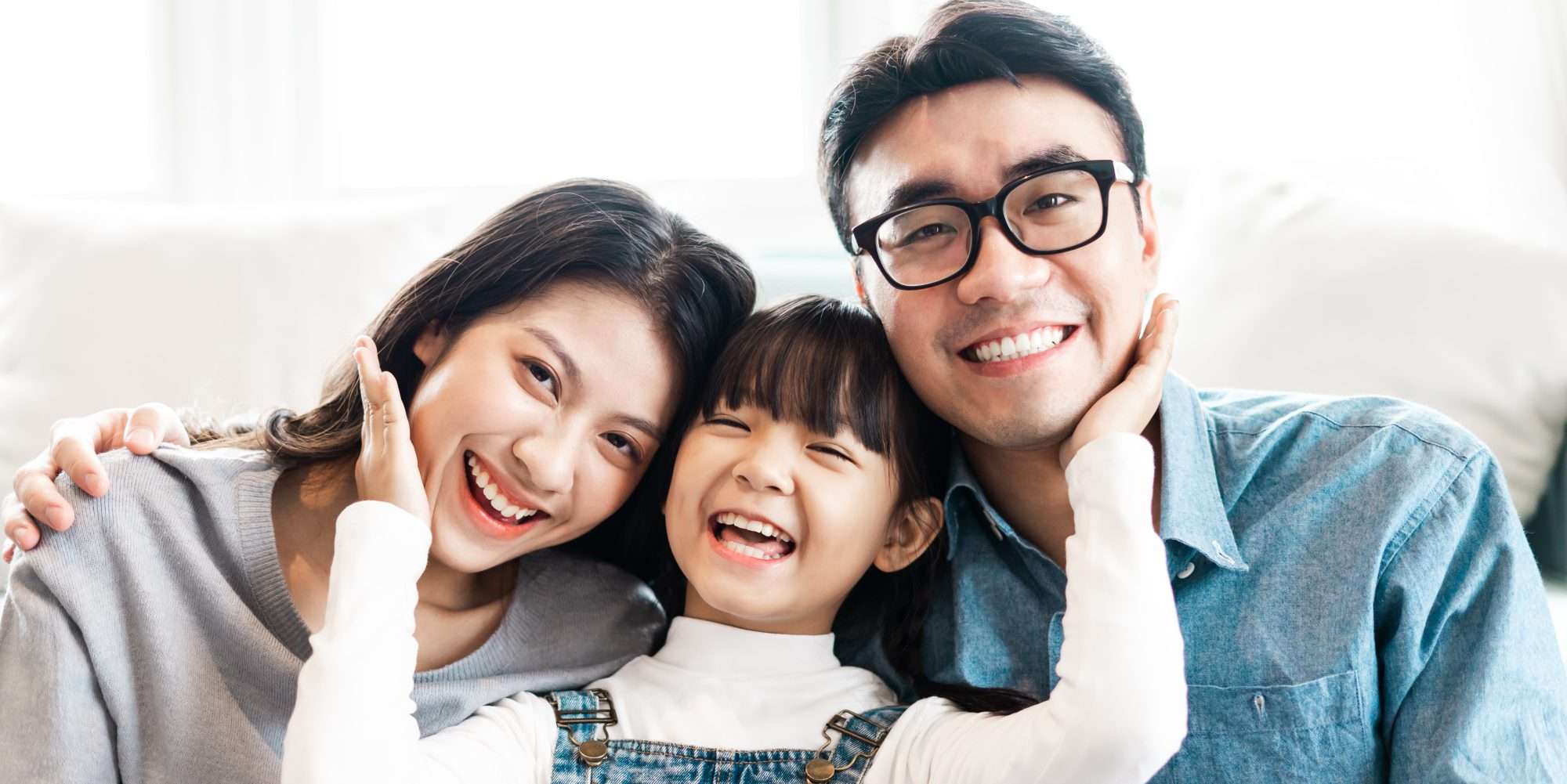Family smiling together in their home after receiving weatherization services