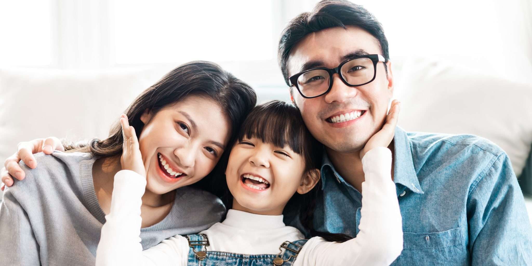 Family smiling together in their home after receiving weatherization services