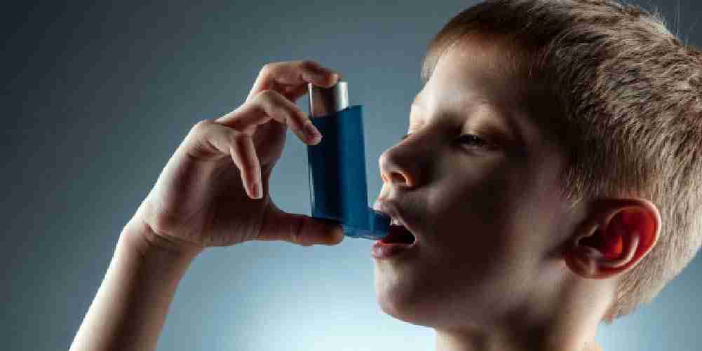 Child using an asthma inhaler to manage respiratory symptoms and improve breathing.