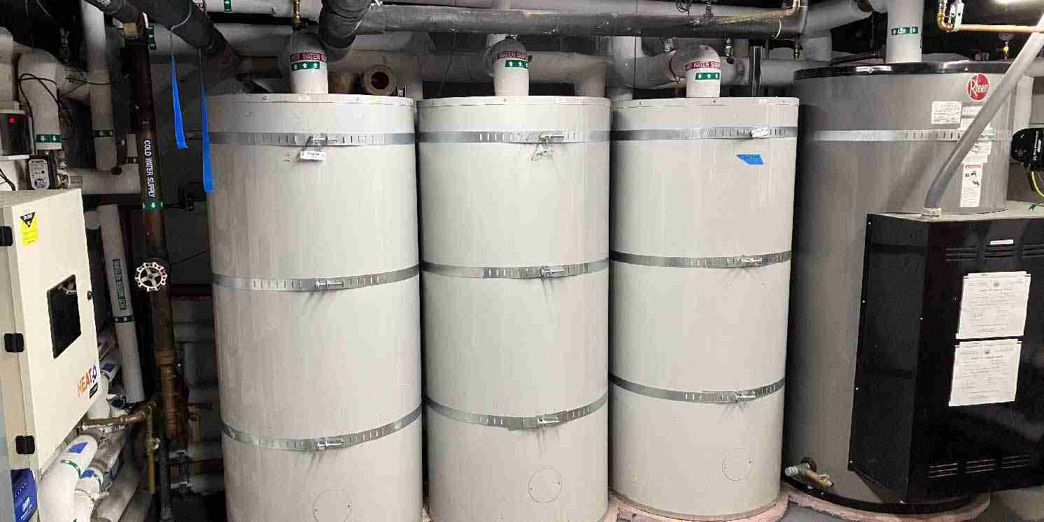 CO₂ central heat pump water heating system with multiple storage tanks