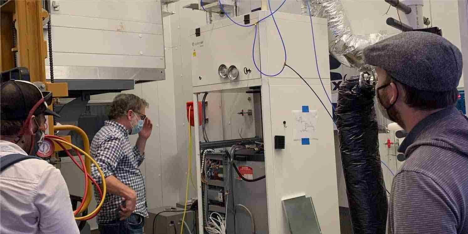 Technicians inspecting integrated mechanical system pod for HVAC systems
