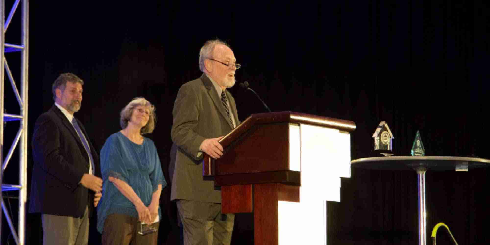 David Hepinstall speaking at a podium while receiving the 2014 ACI Leadership Award at a conference in Detroit