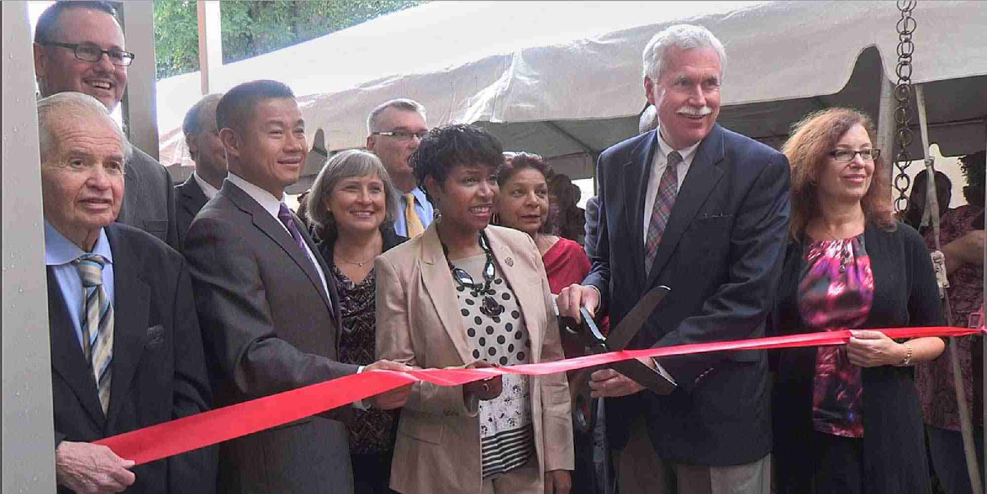 Officials and partners cutting ribbon at Crown Heights affordable housing residence opening