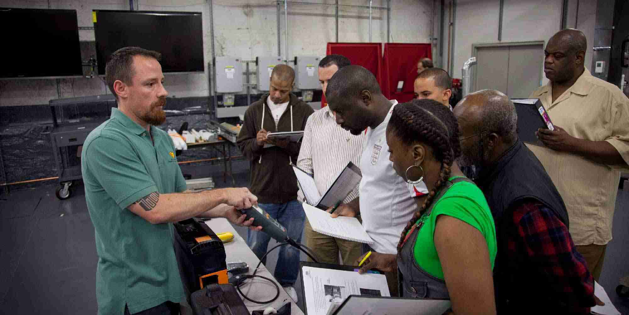 Instructor demonstrating a combustion analyzer to trainees in a boiler lab during energy efficiency training