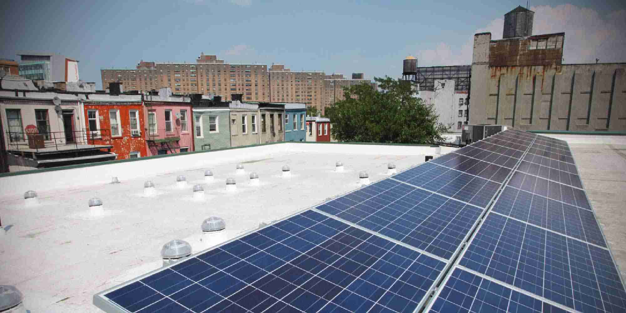 Solar panels installed on a rooftop of a multifamily building in New York as part of an energy efficiency and solar initiative