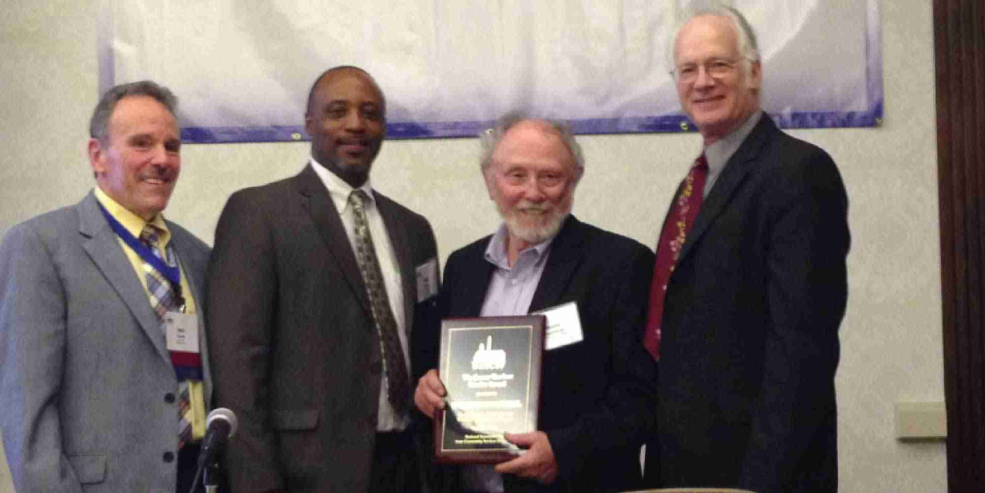 David Hepinstall holding a national weatherization award alongside colleagues at the NASCSP Annual Training Conference