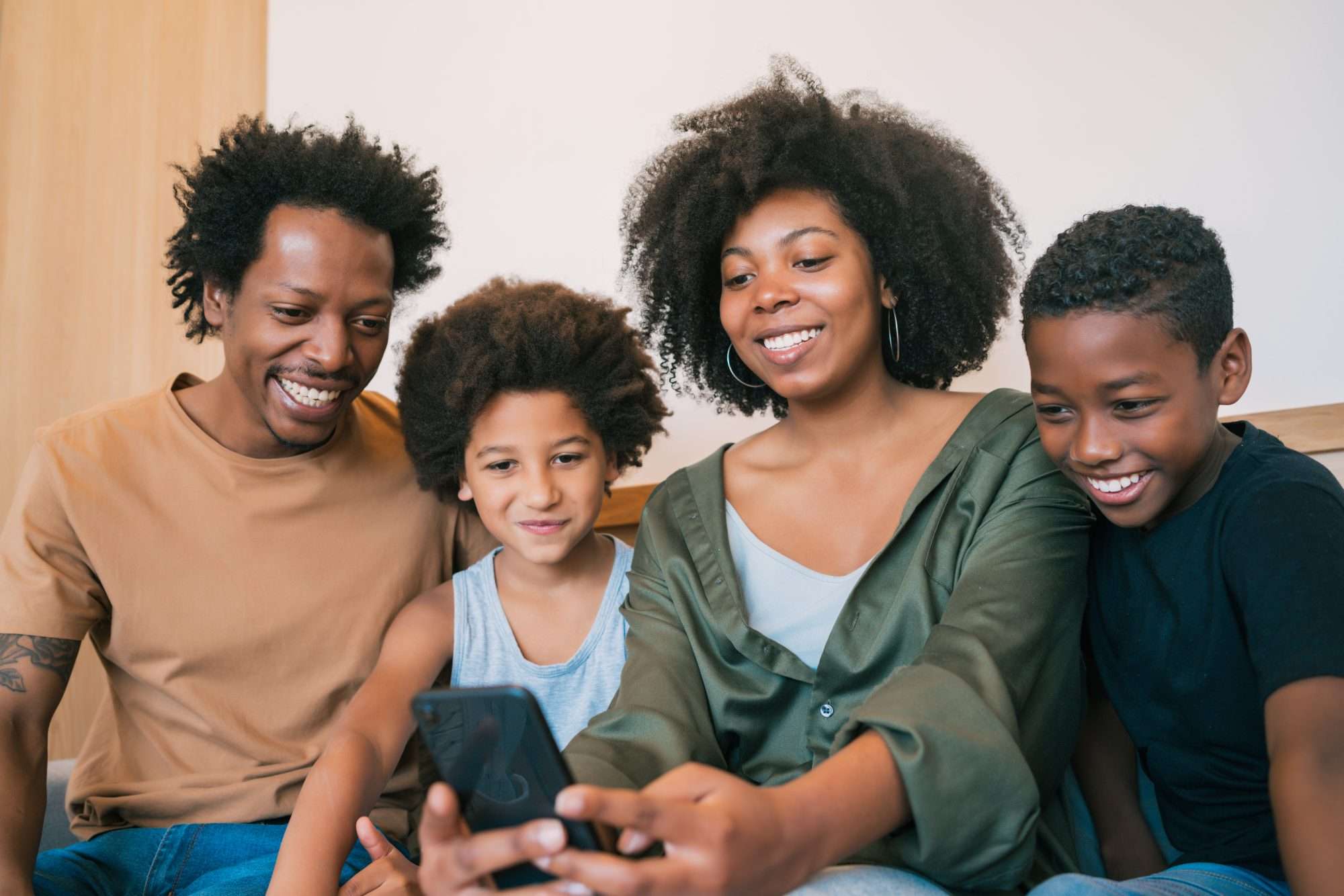 Family sitting together at home taking a selfie with a mobile phone
