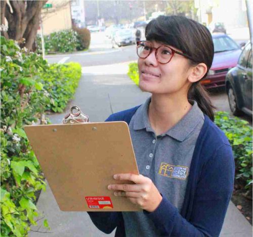 Employee holding a clipboard while collecting building information outdoors